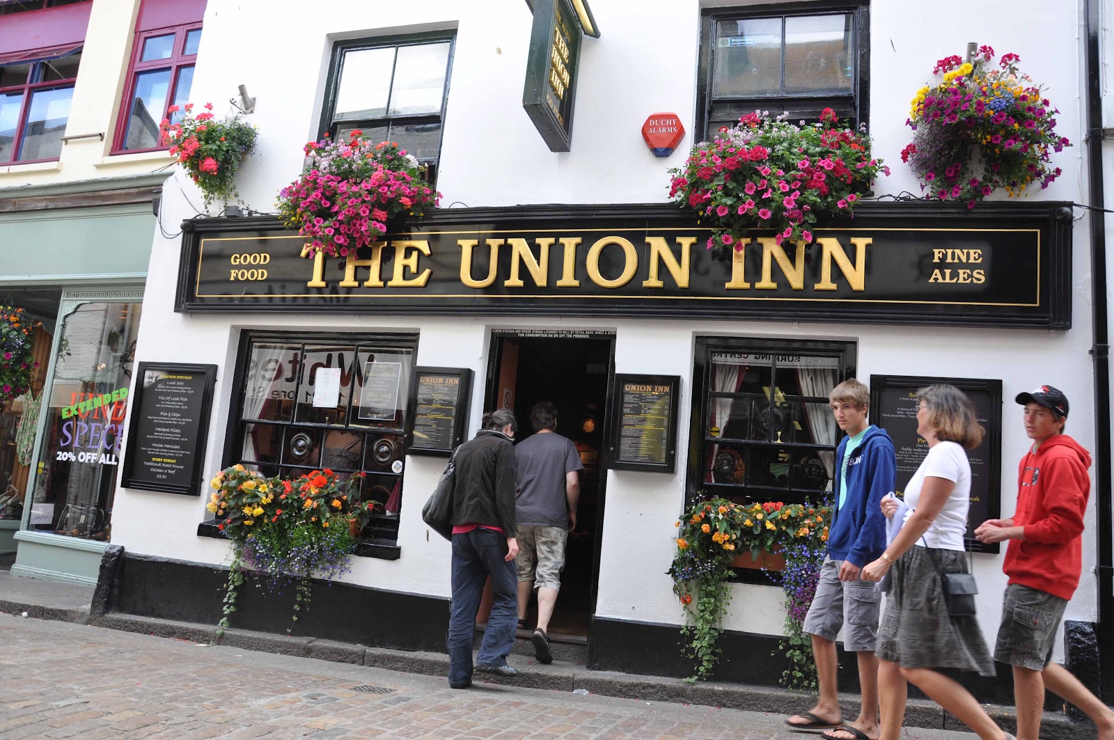 The Union Inn in summer — hanging baskets over the black-and-gold front on Fore Street